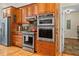 Kitchen featuring stainless steel appliances, wood cabinets, granite countertops, and access to another room at 195 Connesena Rd, Kingston, GA 30145