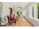 Well-lit sunroom with views of nature, comfortable seating, and wood-look floors at 195 Connesena Rd, Kingston, GA 30145