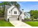 Side angle of charming two-story home with an attached garage and manicured front lawn at 3040 Ivey Oaks Ln, Roswell, GA 30076