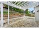 A stone patio with a white pergola with a retaining wall in the background at 3040 Ivey Oaks Ln, Roswell, GA 30076