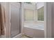 Clean bathroom featuring a soaking tub, a glass shower, and two windows at 3365 Ne Ivy Lake Drive Northeast Dr, Buford, GA 30519