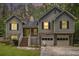 Evening view of the inviting home showcasing a two-car garage and charming front porch at 3365 Ne Ivy Lake Drive Northeast Dr, Buford, GA 30519