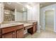 Bathroom featuring double sinks, granite counters, wood cabinets, and a glass-enclosed shower at 4404 Village Field Pl, Suwanee, GA 30024
