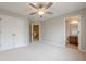 Bedroom featuring neutral walls and carpet, a ceiling fan, double closets, and ensuite bathroom access at 4404 Village Field Pl, Suwanee, GA 30024