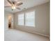 Bright bedroom featuring neutral walls, carpet, a ceiling fan, and ensuite bathroom access at 4404 Village Field Pl, Suwanee, GA 30024