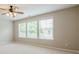 Bright bedroom featuring neutral walls, carpet and three large windows at 4404 Village Field Pl, Suwanee, GA 30024