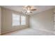 Bedroom showcasing neutral walls and carpet, a ceiling fan, and sunlit windows at 4404 Village Field Pl, Suwanee, GA 30024