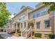 Charming townhome exterior showcasing a well-maintained facade, stairs to the entrance, and lush landscaping at 4404 Village Field Pl, Suwanee, GA 30024