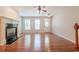 Well-lit living area with hardwood floors, fireplace, ceiling fan, and windows for natural light at 4404 Village Field Pl, Suwanee, GA 30024