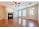 Spacious living room with hardwood floors, fireplace, ceiling fan, and natural light from the windows at 4404 Village Field Pl, Suwanee, GA 30024