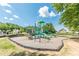 A community playground with green and blue play structures, set in a well-maintained park with blue sky at 4404 Village Field Pl, Suwanee, GA 30024