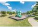 Community playground surrounded by lush landscaping offers a fun recreational space on a clear day at 4404 Village Field Pl, Suwanee, GA 30024