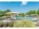 Community pool with lounge chairs and sunshades offers a refreshing oasis under the summer sky at 4404 Village Field Pl, Suwanee, GA 30024