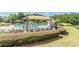 Outdoor community pool area with lounge chairs, umbrellas, and a surrounding green landscape at 4404 Village Field Pl, Suwanee, GA 30024