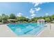 Community pool with lounge chairs, umbrellas, and lush green surroundings at 4404 Village Field Pl, Suwanee, GA 30024