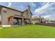 Large backyard featuring a covered patio and shed with ample green space on a sunny day at 206 Traditions Dr, Loganville, GA 30052