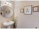 Charming powder room with pedestal sink, decorative mirror, and elegant wall art at 206 Traditions Dr, Loganville, GA 30052
