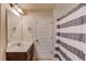 Well-lit bathroom features a vanity with a large mirror and a shower with a striped curtain at 206 Traditions Dr, Loganville, GA 30052