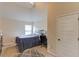 Carpeted bedroom under high ceiling with a bed, workspace, and a door leading elsewhere at 206 Traditions Dr, Loganville, GA 30052