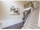 Elegant foyer with staircase, dark wood floors, wainscoting and striking artwork creating a welcoming entrance at 206 Traditions Dr, Loganville, GA 30052