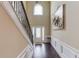 Elegant foyer with dark wood floors, white wainscoting, and a decorative wrought iron banister at 206 Traditions Dr, Loganville, GA 30052