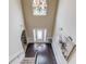 View from above the foyer with dark hardwood floors, staircase, arched window and modern artwork at 206 Traditions Dr, Loganville, GA 30052