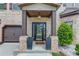 Inviting front entrance with brick columns, decorative planters, and a stylish front door at 206 Traditions Dr, Loganville, GA 30052