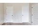 Hallway featuring three doors and neutral colored walls and carpet at 206 Traditions Dr, Loganville, GA 30052