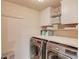 Bright laundry room with modern washer, dryer, white cabinets, and plenty of shelving at 206 Traditions Dr, Loganville, GA 30052