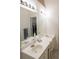 Bright bathroom featuring dual sinks, a large mirror, white cabinetry, and modern lighting fixtures at 2407 Cove Lake Way, Lithonia, GA 30058