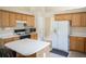 Kitchen with wooden cabinets, white countertops, gas range, stainless steel microwave, and a white refrigerator at 2407 Cove Lake Way, Lithonia, GA 30058
