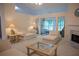 Bright living room with plush carpeting, fireplace, and large windows looking into the sunroom at 2407 Cove Lake Way, Lithonia, GA 30058