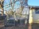 Elevated back deck with stairs offers a view of the wooded backyard with mature trees at 3254 Howell Cir, Duluth, GA 30096