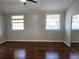 A bedroom featuring hardwood floors, two windows, and a large mirrored sliding door closet at 3254 Howell Cir, Duluth, GA 30096