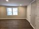 Bedroom featuring updated flooring, neutral paint, natural light, and a double door closet at 3254 Howell Cir, Duluth, GA 30096