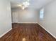 Living room with dark hardwood floors, a ceiling fan, and a white door to another room at 3254 Howell Cir, Duluth, GA 30096