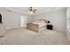 Bright main bedroom with a tray ceiling, neutral paint, plush carpet, and a connecting bathroom at 3569 Tupelo Trl, Auburn, GA 30011