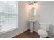 Half bathroom featuring pedestal sink, wood-look floor and natural light from a window at 5589 Trace Views Dr, Norcross, GA 30071