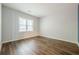 Spacious empty bedroom with hardwood floors, neutral walls, and ample natural light from the window at 5589 Trace Views Dr, Norcross, GA 30071