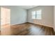Empty bedroom showcasing new hardwood floors, fresh paint, and a bright window at 5589 Trace Views Dr, Norcross, GA 30071