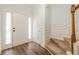 Bright foyer with hardwood floors, a staircase, and a paneled white front door at 5589 Trace Views Dr, Norcross, GA 30071