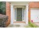 Welcoming front entrance with decorative columns, an olive green door, and manicured landscaping at 5589 Trace Views Dr, Norcross, GA 30071