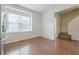 Hallway leading to staircase with wood-look floors and natural light from a large window at 5589 Trace Views Dr, Norcross, GA 30071