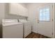 Functional laundry room with white appliances, ample cabinet storage, and a convenient exterior door at 5589 Trace Views Dr, Norcross, GA 30071
