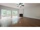 Bright living room with fireplace, ceiling fan, and sliding glass doors to wooden deck and backyard at 5589 Trace Views Dr, Norcross, GA 30071