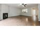 Bright open concept living room with fireplace, ceiling fan, and view into kitchen area at 5589 Trace Views Dr, Norcross, GA 30071