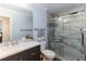 Bright bathroom featuring a vanity with marble countertop, a toilet, and a glass-enclosed shower at 1547 Paxton Sw Dr, Lilburn, GA 30047
