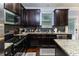 Modern kitchen featuring stainless steel appliances, granite countertops, and sleek dark cabinets at 1547 Paxton Sw Dr, Lilburn, GA 30047