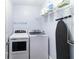 Bright laundry room features modern washer and dryer, shelving, and an ironing board for added convenience at 1547 Paxton Sw Dr, Lilburn, GA 30047