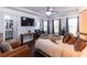 Bright main bedroom featuring a sitting area and en-suite bathroom, a ceiling fan with a chandelier, and hardwood floors at 1547 Paxton Sw Dr, Lilburn, GA 30047